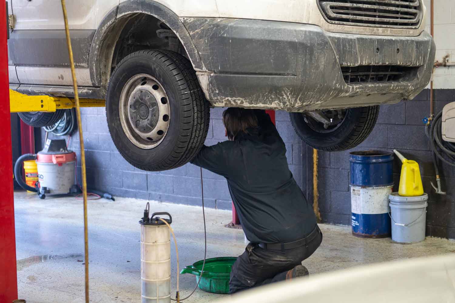 automotive tech working on a van in the service bay